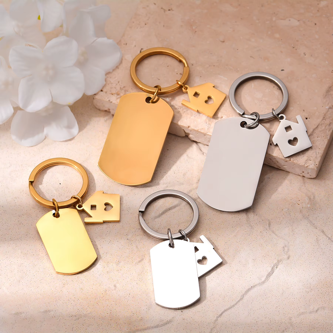 Schlüsselanhänger in Gold und Silber mit Gravurplatte und kleinem Hausanhänger