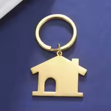 Goldfarbener Schlüsselanhänger in Hausform mit Türausschnitt